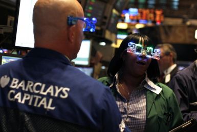 Traders wear &quot;2012&quot; glasses as they work on the main trading floor of the New York Stock Exchange during the final trading day of 2011 in New York December 30, 2011.