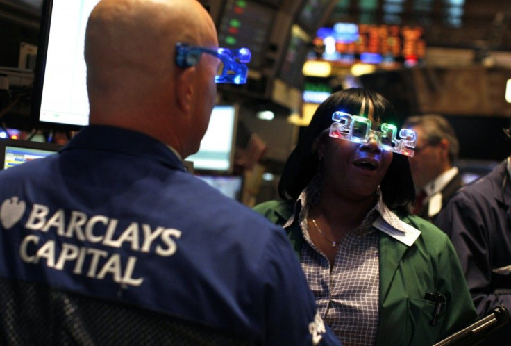 Traders wear &quot;2012&quot; glasses as they work on the main trading floor of the New York Stock Exchange during the final trading day of 2011 in New York December 30, 2011.
