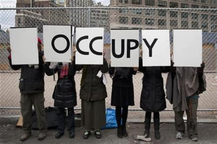 Protesters affiliated with the Occupy Wall Street movement stand with signs outside Duarte Square in New York