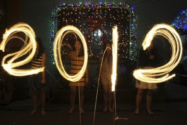 Women use sparklers to draw quot2012quot for photographers, in front of a house, as they celebrate New Years Eve in Manila December 31, 2011.