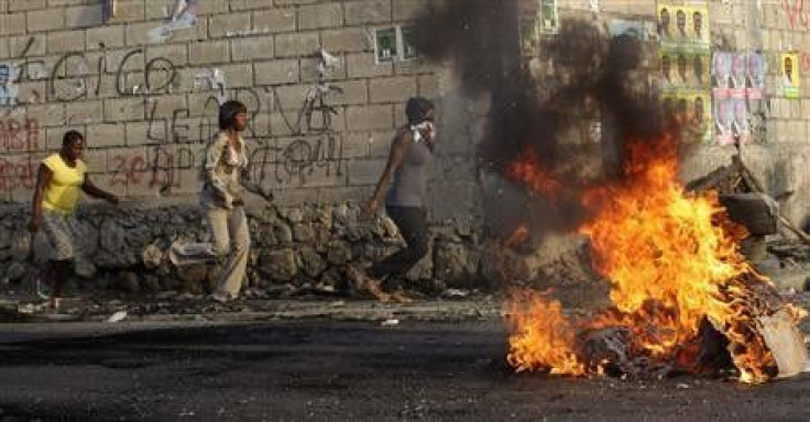 Haitians run on the street while tires burn during a protest in Port-au-Prince 
