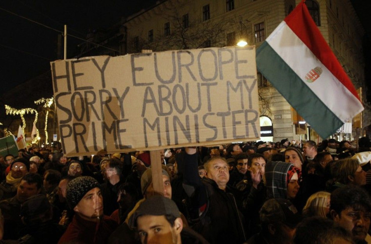 A man holds up a sign during a protest in central Budapest