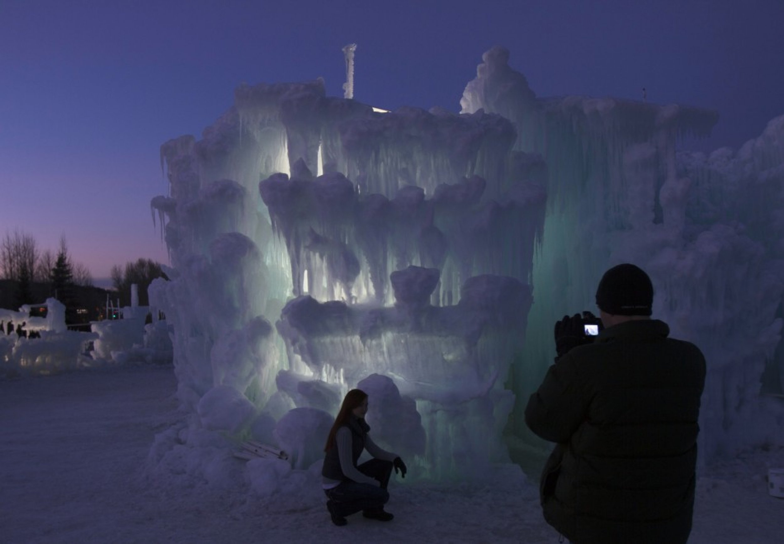 A tourist poses with ice formations at the Ice Castles at Silverthorne in Colorado