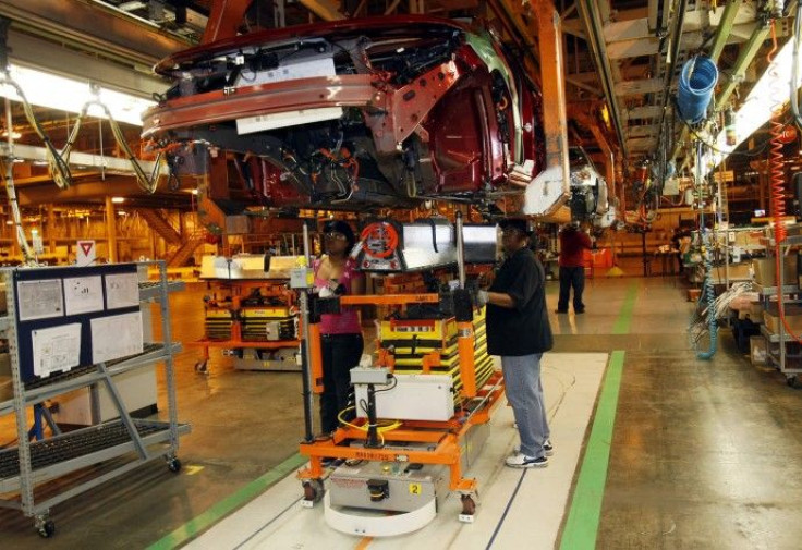 General Motors assembly workers Monique Watson and Evetta Osborne install an electric battery on the underside of a 2011 Chevrolet Volt electric vehicle at the Detroit-Hamtramck Assembly plant in Hamtramck, Michigan