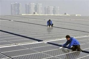 Technicians maintain solar panels on a roof at a solar power plant in Wuhan, Hubei province