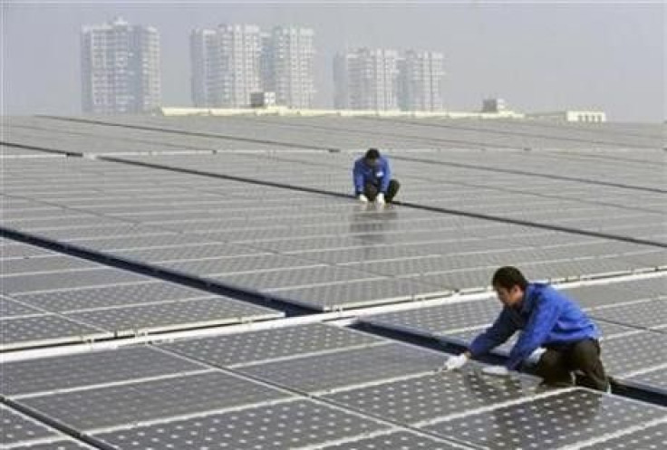 Technicians maintain solar panels on a roof at a solar power plant in Wuhan, Hubei province