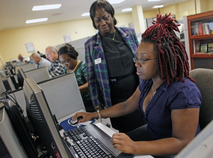 Shaneika Smith (R) of West Palm Beach, FL, fills out an online job application with the help of career consultant Verdina Coleman (C) at the Workforce Alliance Career Center in West Palm Beach, Florida December 2, 2010.