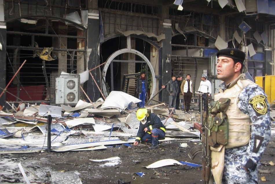 A police officer provides security at the site of a bomb attack in Baghdad039s northwestern Kadhimiya district