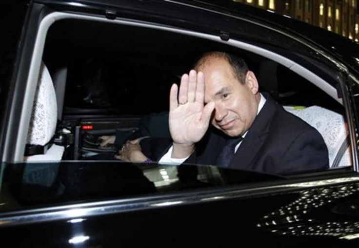 Former Olympus CEO Michael Woodford waves from a car window as he leaves at a news conference at the Japan National Press Club in Tokyo