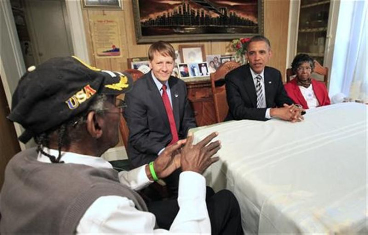 U.S. President Barack Obama listens as William Eason speaks during a visit with the Eason family in Cleveland