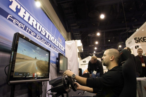 Corrado Amenta, tries out a driving simulation game with Thrustmaster steering wheels and pedals by Guillemot Corp. during the 2011 International Consumer Electronics Show (CES) in Las Vegas