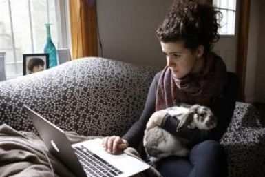 Molly Katchpole works on her laptop, along with her rabbit Crackers, in Washington, January 4, 2012. Corporate America&#039;s worst nightmare lives in a tiny one-bedroom apartment, loves browsing in flea markets and has a pet rabbit named Crackers. Katchp