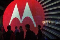 People pass by the Motorola booth during the 2011 International Consumer Electronics Show (CES) in Las Vegas