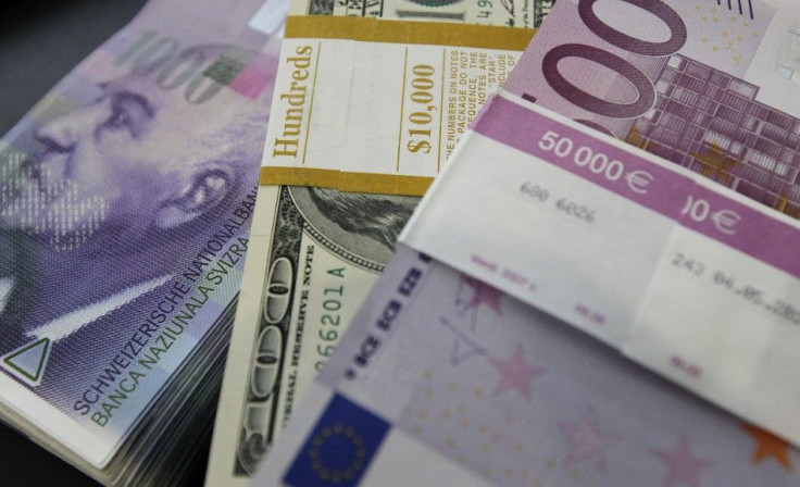 Stacks of Swiss franc, Euro and U.S. dollar banknotes are displayed in a bank in Bern August 15, 2011.