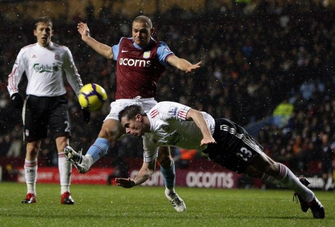 Liverpool's Carragher heads clear of Aston Villa's Young during their English Premier League soccer match in Birmingham on 29/12/2009.