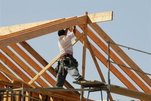 A construction worker works on the framework for a single family home currently under construction in Los Angeles