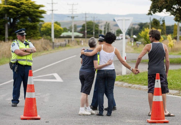 People react as they stand at a police road block near the scene of a hot air balloon crash near Caterton in New Zealand