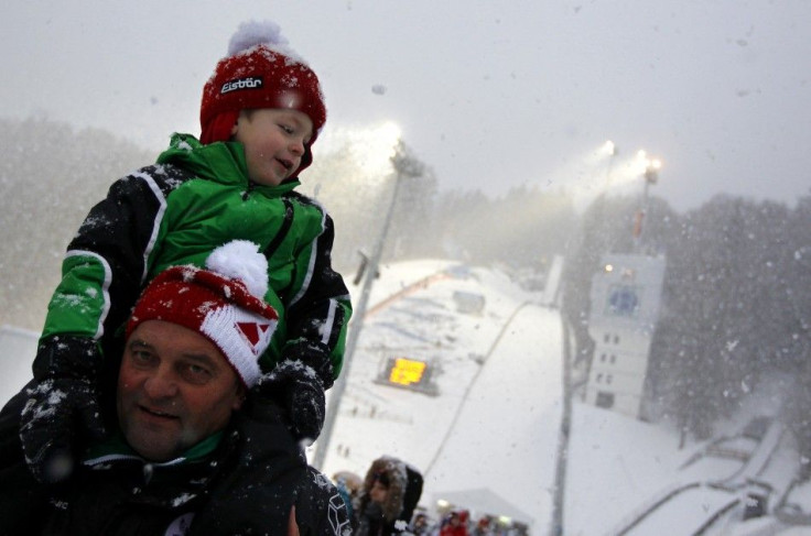Spectators leave the stadium in heavy snow fall after the qualification for the fourth event of the 60th four-hills ski jumping tournament was cancelled in Bischofshofen