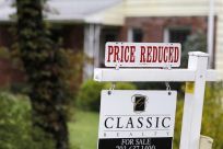 A &quot;Price Reduced&quot; sign is displayed on a home for sale in northern Virginia suburb of Vienna