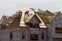 A builder works on the the roof of a new home under construction in the Montreal suburb of Brossard