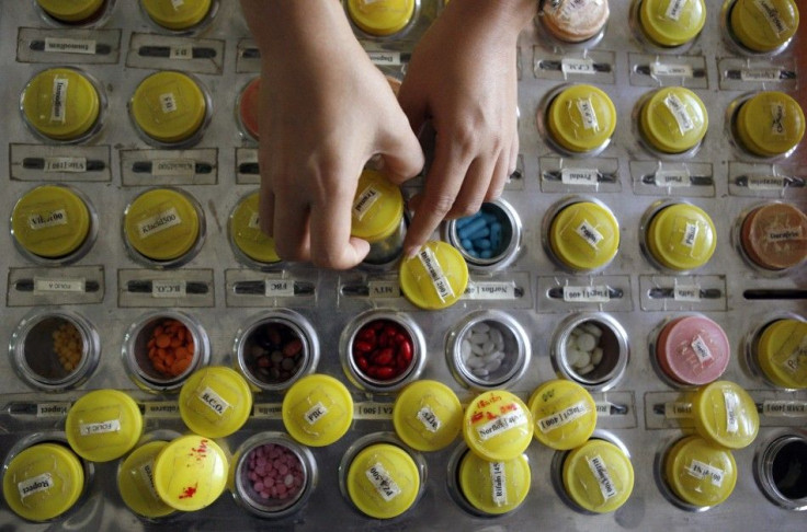 A nurse prepares doses of brand name and generic HIV-AIDS drugs for patients