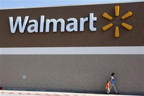 People walk past a Wal-Mart sign in Rogers, Arkansas
