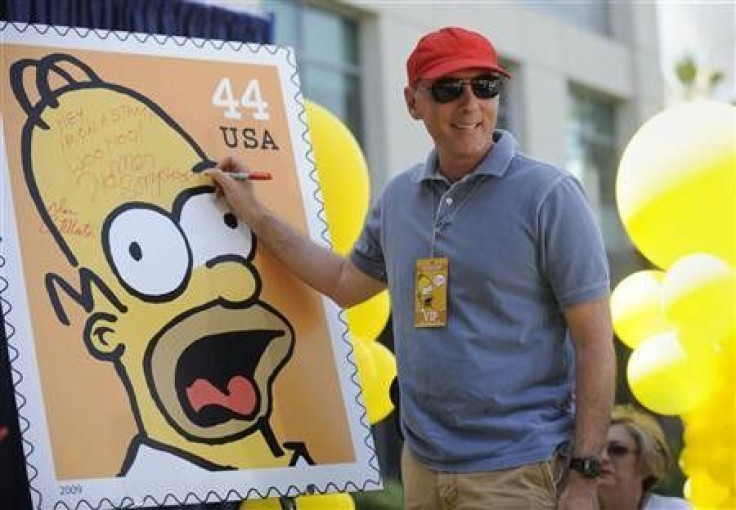 Dan Castellaneta, the voice of Homer Simpson, signs a poster at the unveiling of the new &#039;&#039;The Simpsons&#039;&#039; U.S. postage stamps in Los Angeles