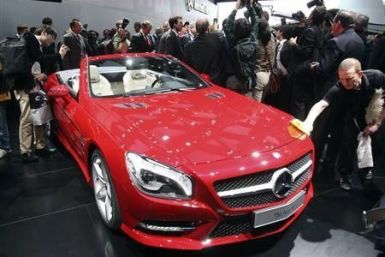 A worker removes fingerprints from the 2013 Mercedes Benz SL on the first press preview day at the North American International Auto Show in Detroit, Michiganon the first press preview day in Detroit, Michigan, January 9, 2012.