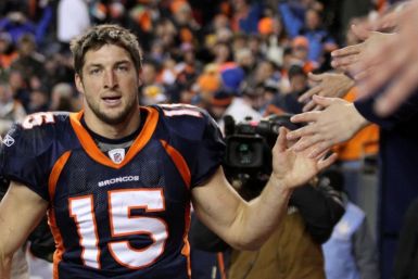 Denver Broncos quarterback Tim Tebow celebrates with fans after the Broncos defeated the Pittsburgh Steelers in overtime in the NFL AFC wildcard playoff football game in Denver