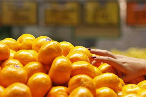 A woman picks up some mandarin oranges at a fruit shop