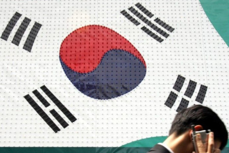 A man walks past a sign resembling a South Korean flag in Seoul