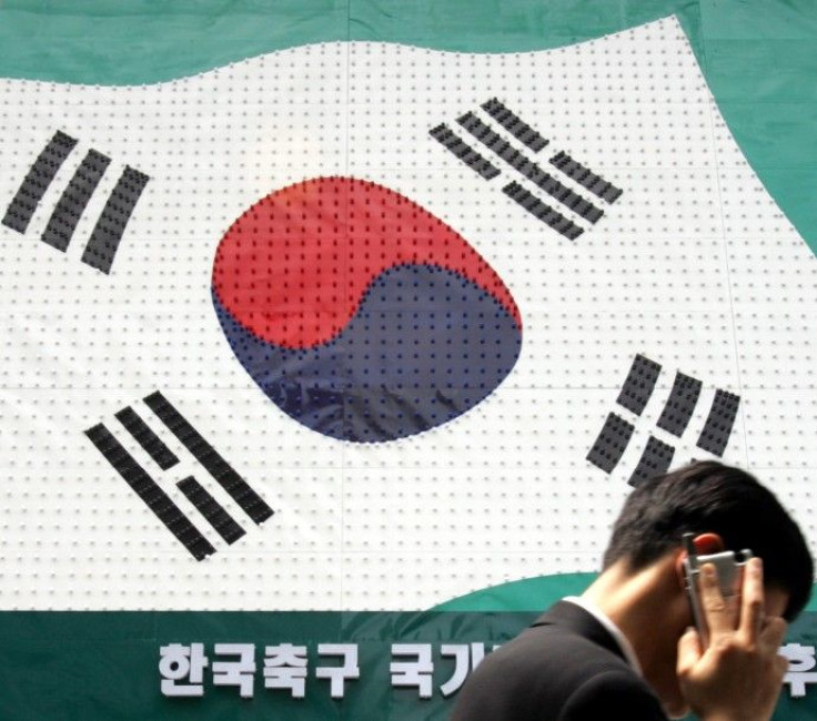 A man walks past a sign resembling a South Korean flag in Seoul