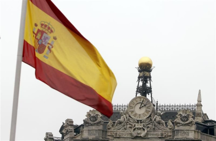 A Spanish flag flutters near the dome of the Bank of Spain in central Madrid