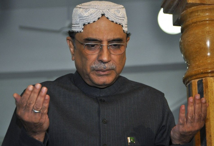 Pakistan&#039;s President Zardari, widower of assassinated former PM Benazir Bhutto, raises his hands in prayer at her grave to mark her death anniversary at the Bhutto family mausoleum in Garhi Khuda Bakhsh