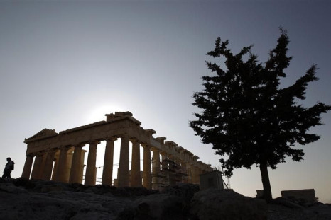 A tourist walks in front of the Parthenon temple at the Acropolis in Athens