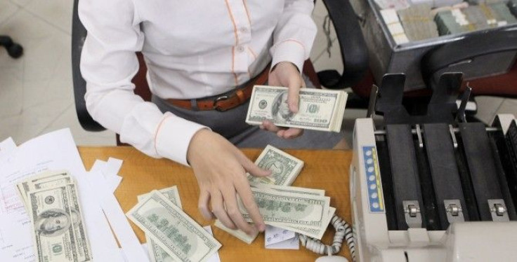 A bank staff counts U.S. dollar notes at a bank in Hanoi November 29, 2010. 