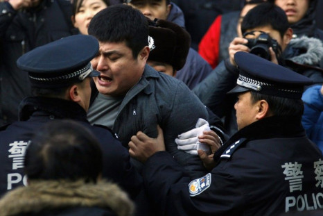 A man is dragged away by police after he refused to leave from the front of the Apple store in the Beijing district of Sanlitun