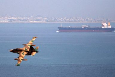 An Iranian military fighter plane flies past an oil tanker during naval maneuvres in the Persian Gulf and Sea of Oman April 5, 2006.