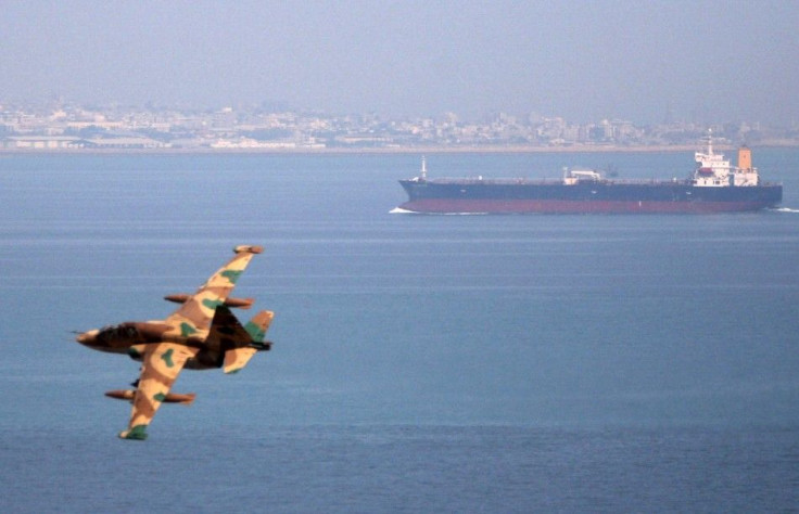 An Iranian military fighter plane flies past an oil tanker during naval maneuvres in the Persian Gulf and Sea of Oman April 5, 2006.