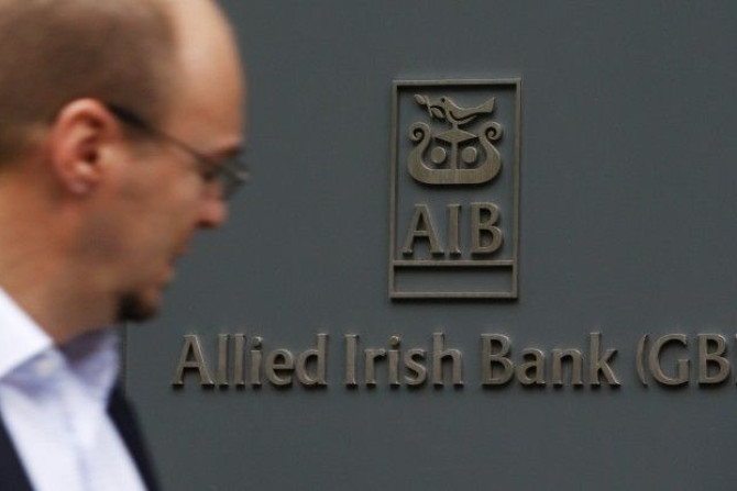 A pedestrian passes a branch of Allied Irish Bank in London