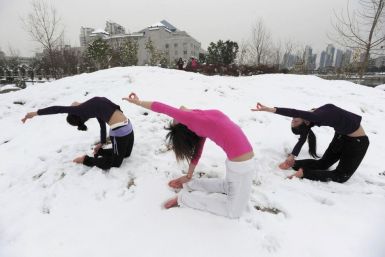 Local residents practise yoga after a snowfall at a park in Wuhan, Hubei province January 6, 2010.