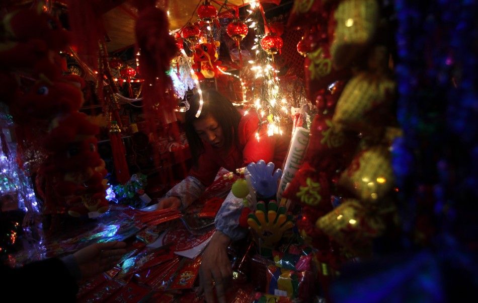 A vendor stands inside her shop selling Chinese New Year products at a market in downtown Shanghai