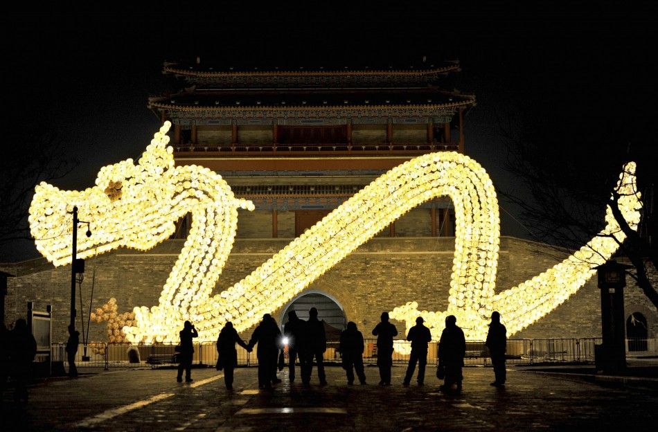 Visitors take pictures in front of a dragon-shaped lantern which has been set up for the upcoming Lunar New Year in Beijing