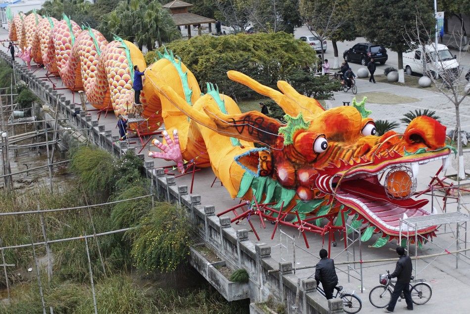 Workers decorate a dragon-shaped sculpture ahead of the Chinese New Year in Wenzhou
