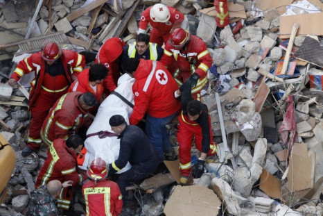 Lebanese Red Cross and Civil Defence personnel transport a dead body found under the debris of a collapsed building in Beirut