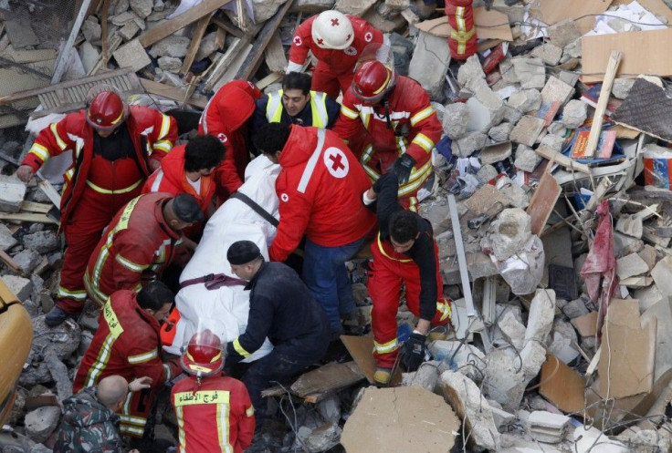 Lebanese Red Cross and Civil Defence personnel transport a dead body found under the debris of a collapsed building in Beirut