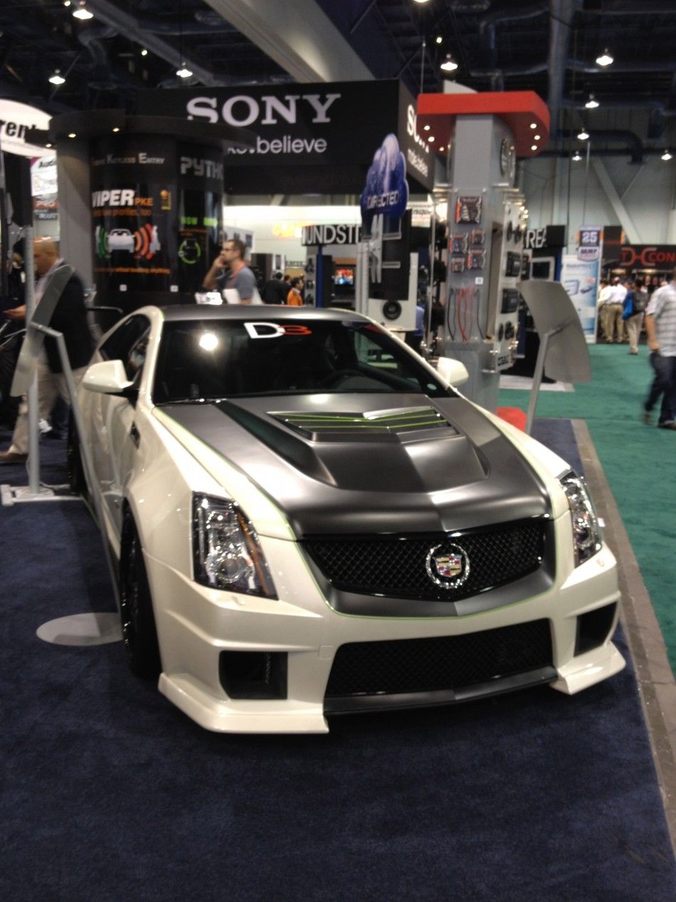 A customized Cadillac features a suped-up hood.