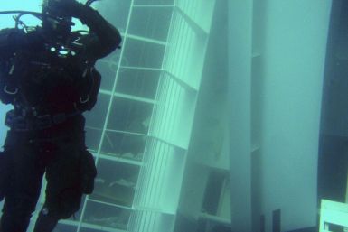 A scuba diver inspects a side of the Costa Concordia cruise ship, seen underwater after it ran aground off the west coast of Italy, at Giglio island