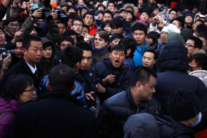 A man yells at a security guard after the guard tried to remove a member of the crowd at the Apple store in the Beijing district of Sanlitun