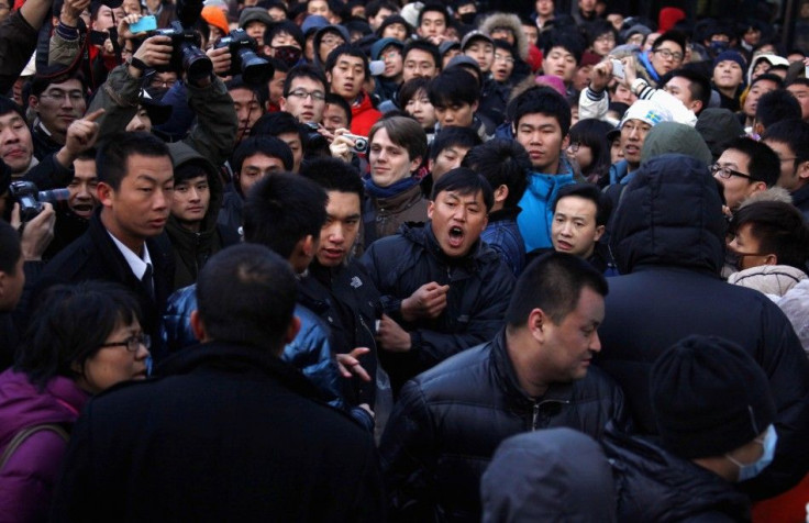 A man yells at a security guard after the guard tried to remove a member of the crowd at the Apple store in the Beijing district of Sanlitun